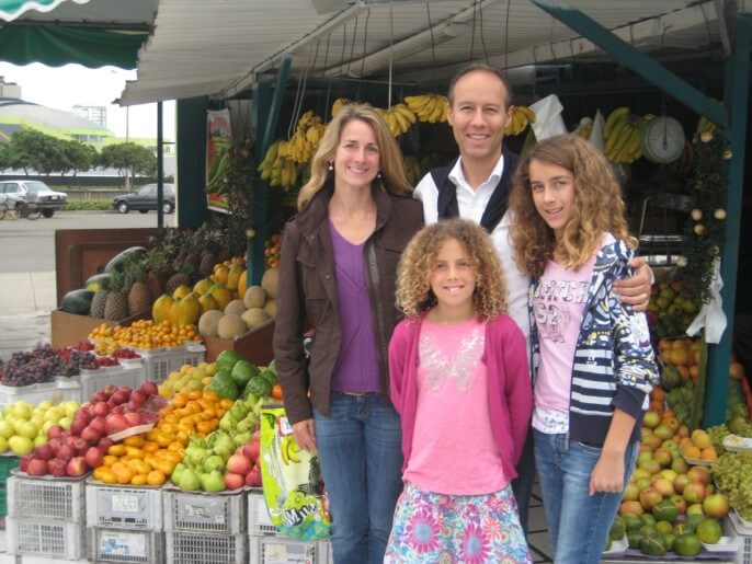 Family with two school-aged daughters at a market in Lima. Family-friendly trips from Responsible Travel Peru