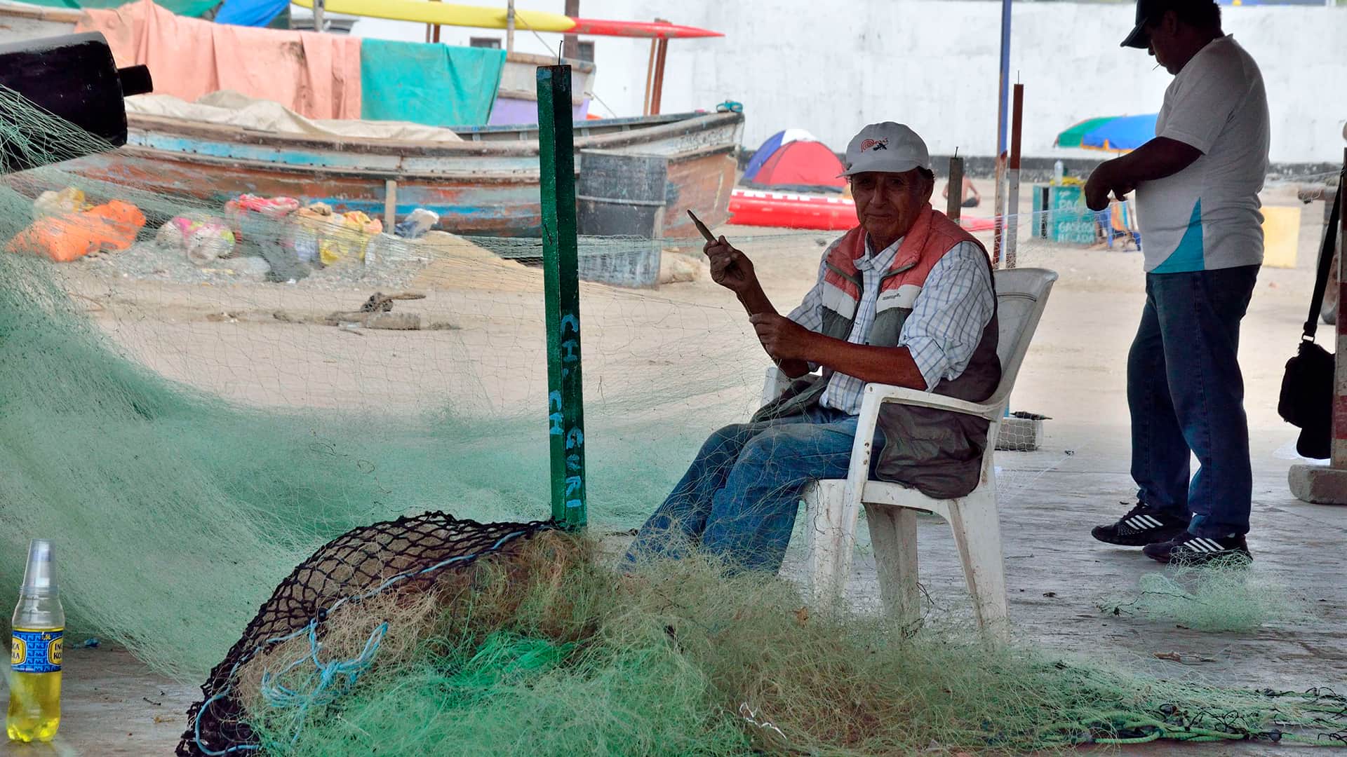 Fisherman fixing his net at Chorrillos dock | Responsible Travel Peru