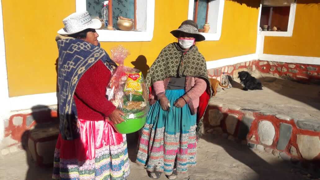 Local lady with tourist homestay in Sibayo, Colca Canyon, donates food and items to another lady from her community after having received donations from RESPONSible Travel Peru clients and team members in corona times.