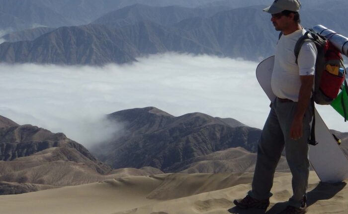 The traveler carrying his sand plate from the top of Cerro Blanco | Responsible Travel Peru