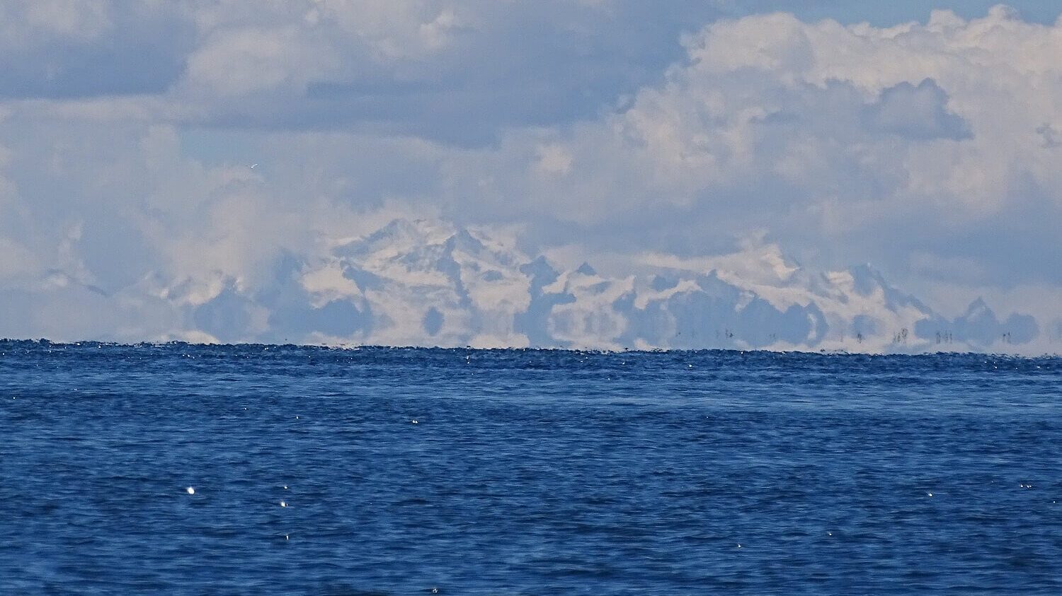 Double horizon on Lake Titicaca as Bolivia's Cordillera Real peaks out above the horizon. Spectacular view as seen during a tour with RESPONSible Travel Peru
