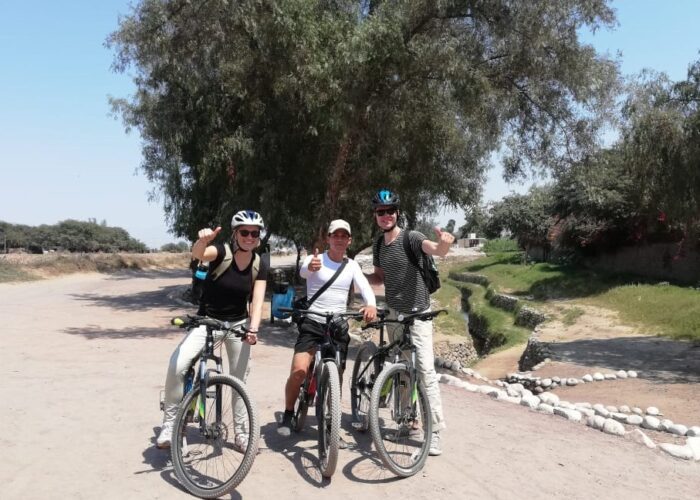 Travelers and local guide arriving to Cantayoc aqueducts on bicycles