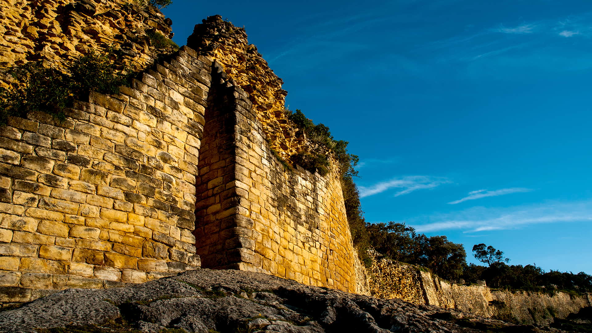 Kuelap's slim entrance in a yellowish rock wall that seems to be infinite along the mountain ridge | Responsible Travel Peru
