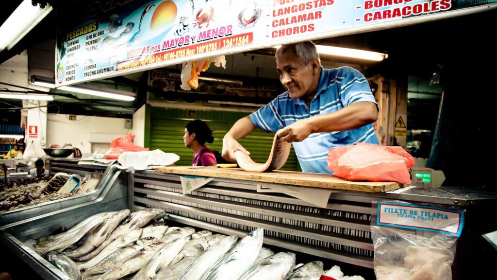 Fish vendor showing his product at the market | Responsible Travel Peru