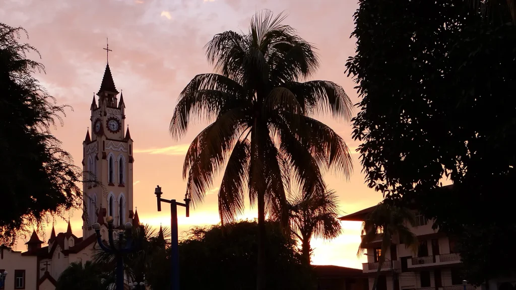 Iquitos Cathedral tower among the tall trees of the main square at sunset | RESPONSible Travel Peru