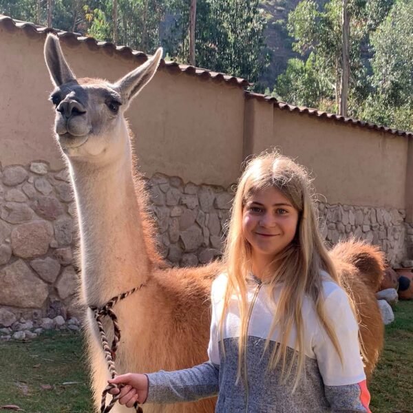 Teen traveler posing with a llama on a hike with RESPONSible Travel Peru
