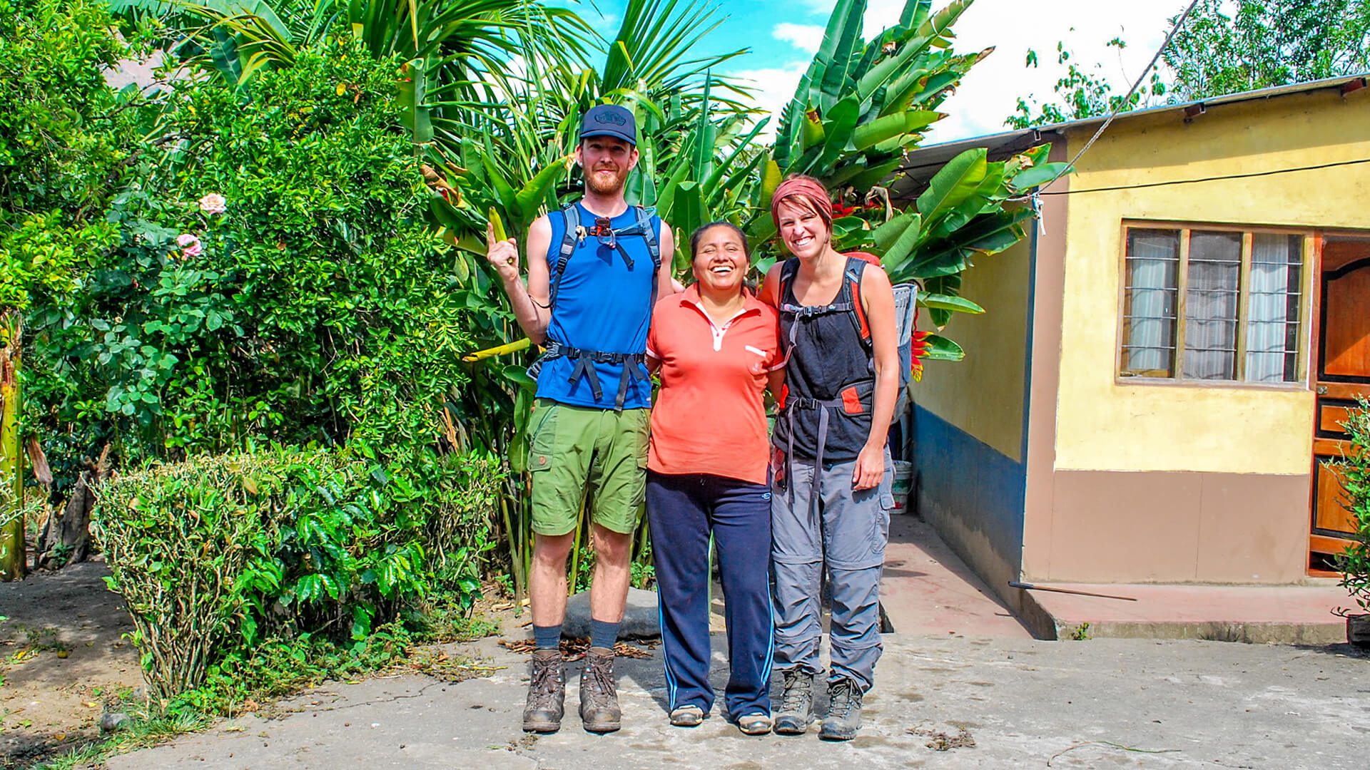 A couple of young travelers with Julia, one of our Coffee Route hosts, at her garden | RESPONSible Travel Peru