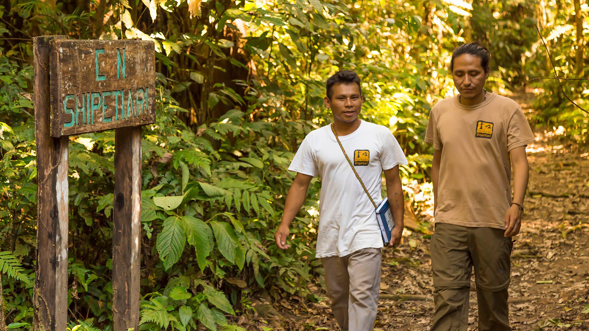 Angel (young Matsigenka) and Rosbert from our Ops Team walking along the trail connecting Shipetiari and the Pankotsi Lodge in Manu - RESPONSible Travel Peru