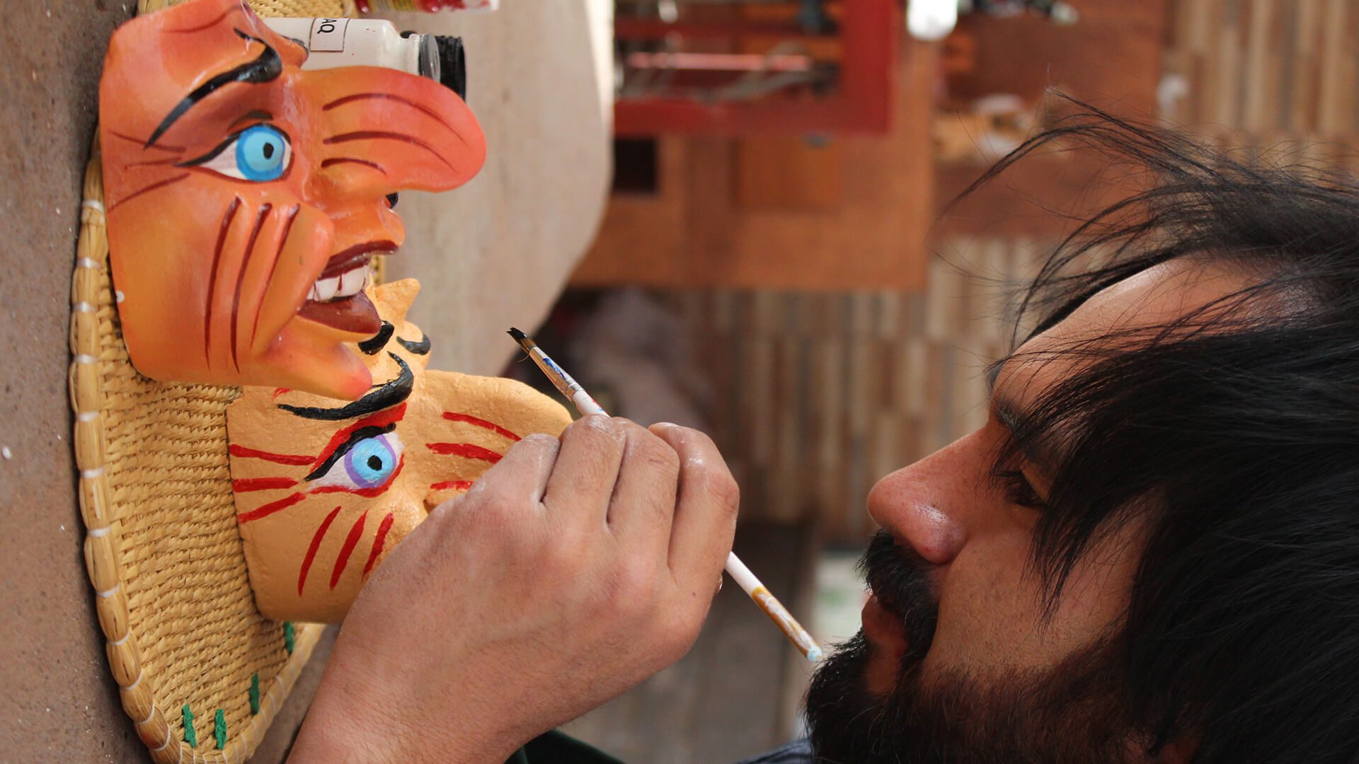 A man painting Paucartambo masks from up close - RESPONSible Travel Peru