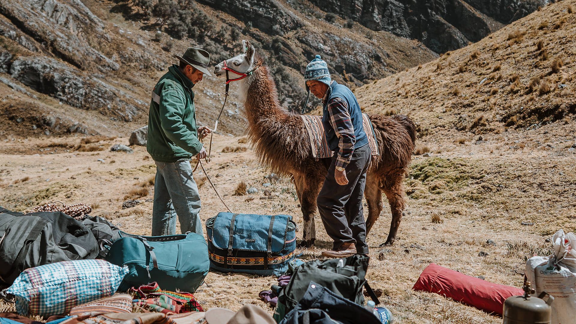 Men loading up a llama with packs along the Llama Trek Olleros to Chavin with RESPONSible Travel Peru | Photo by Bjorn Snelders