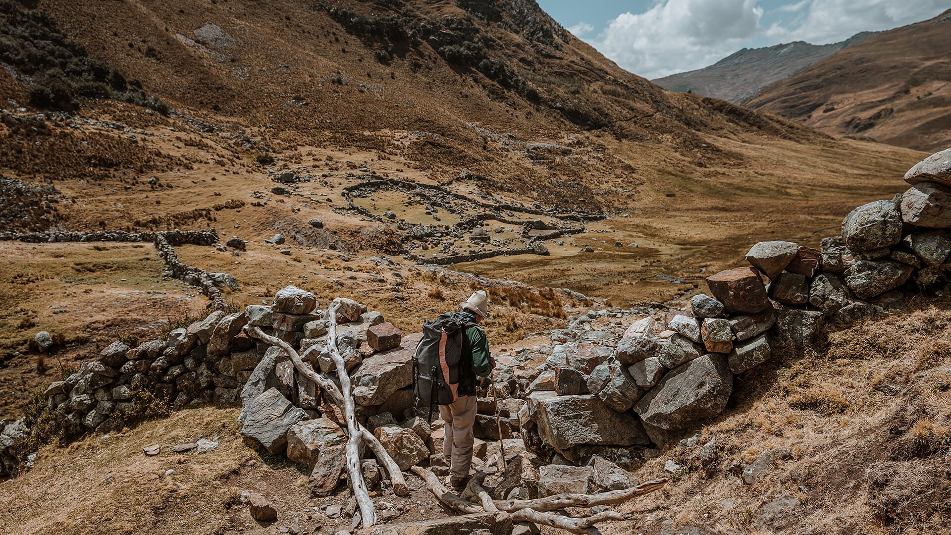 Trekker crossing rock corral in the Peruvian Andes | Hike the Cordillera Blanca with RESPONSible Travel Peru | Photo by Bjorn Snelders
