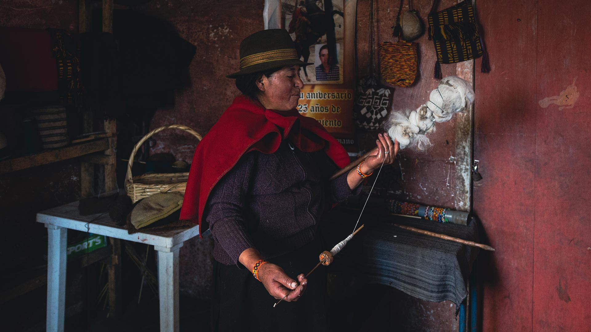 An indigenous Andean woman is yarning wool with a drop spindel near Guamote, Chimborazo, on one of the community visits from the Inti Sisa Guesthouse with Impactful Travel