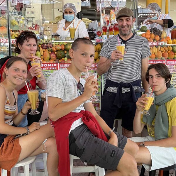A family of five having juice at the San Camilo market in Arequipa, Peru